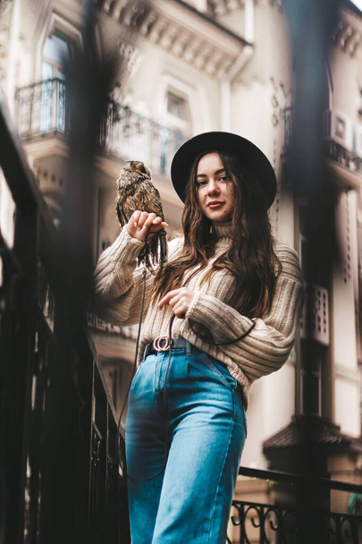 young beautiful girl in a sweater and hat with an owl. - Foto, Imagen