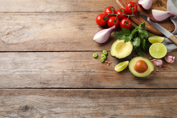 Fresh guacamole ingredients on wooden table, flat lay. Space for text - Φωτογραφία, εικόνα