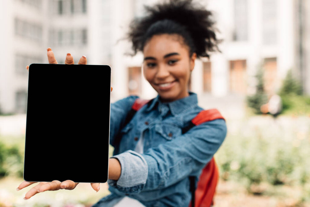 Afrikaans Amerikaans student meisje toont digitale tablet blanco scherm buiten - Foto, afbeelding
