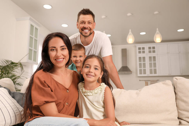 Portrait of happy family on sofa at home - Foto, Imagem