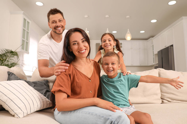 Portrait of happy family on sofa at home - Foto, Imagen