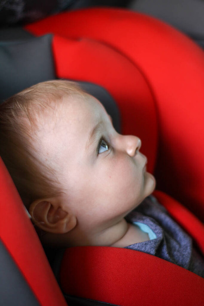 車の座席に生まれたばかりの赤ん坊。子供の安全よ。子供の保護。シートベルト. - 写真・画像