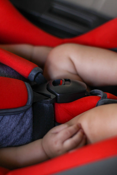 little newborn baby in a car seat. safety of children. protection of children. seat belts. - Photo, Image