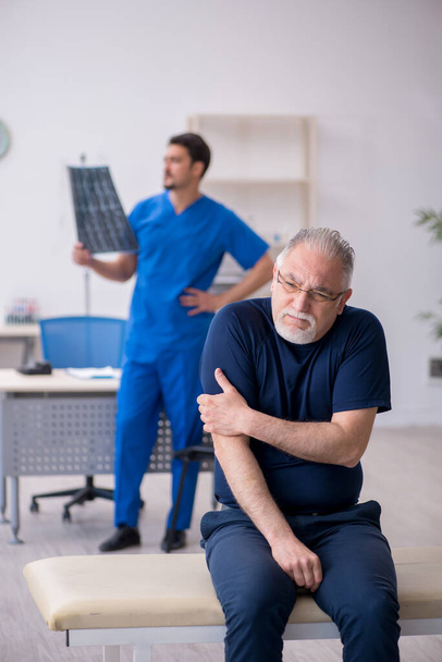 Homem velho visitando jovem médico radiologista masculino - Foto, Imagem