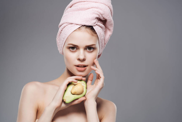 bonita mujer desnuda hombros con fruta aguacate posando de cerca - Foto, Imagen