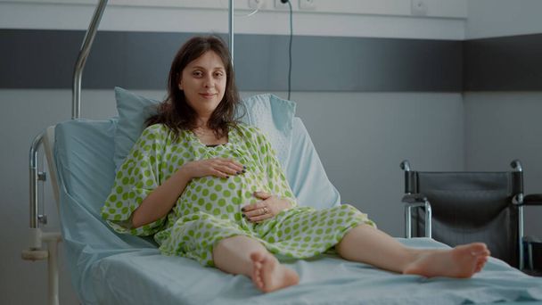 Portrait of pregnant caucasian woman sitting in hospital ward - Photo, Image