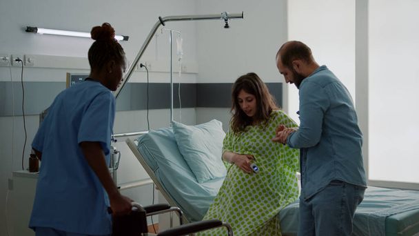 Mari et infirmière afro-américaine aidant femme enceinte - Photo, image