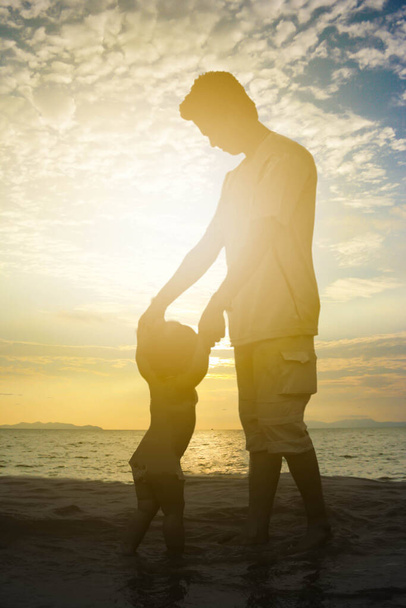Dad play with his daughter at the beach with sun set sky - Foto, imagen
