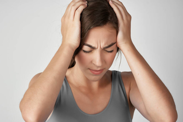vrouw in grijs t-shirt houden haar hoofd depressie migraine stress - Foto, afbeelding