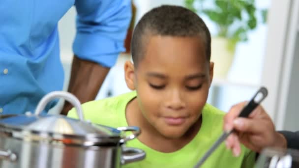 Padres étnicos Hijo joven disfrutando de una cocina casera saludable juntos
 - Imágenes, Vídeo