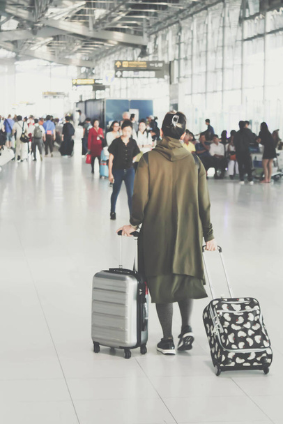personnes floues avec des bagages marchant à l'aéroport ou dans le hall d'affaires : pour une utilisation en arrière-plan - Photo, image