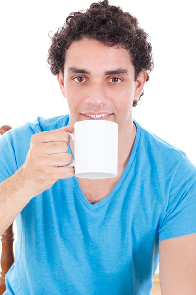 man in blue t-shirt sitting and drinking a cup of tea of coffee - Φωτογραφία, εικόνα