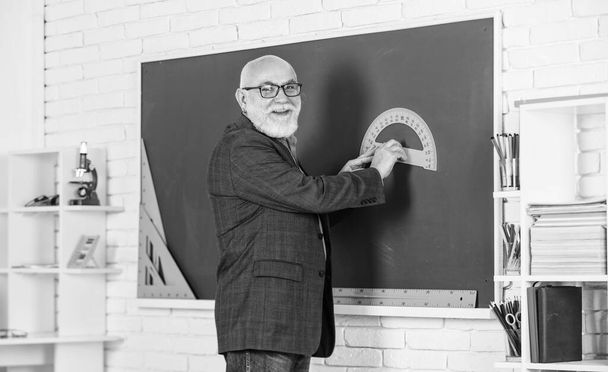 learn geometry easily. become good at math. stem in classroom. senior man teacher use tool at blackboard. bearded tutor in glasses. back to school. protractor ruler. physics and mathematics - Photo, Image