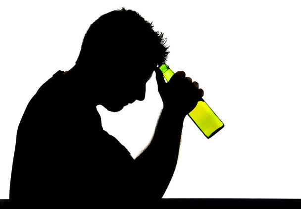 Silhouette of alcoholic drunk man drinking beer bottle feeling depressed suffering alcoholism and addiction problem - Photo, Image