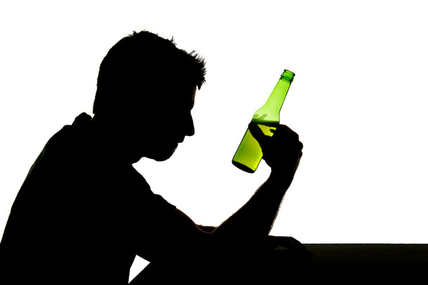 silhouette of alcoholic drunk man drinking beer bottle feeling depressed falling into addiction problem - Photo, Image