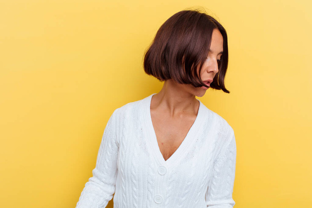 Young mixed race woman isolated on yellow background excited holding a copy space on palm. - Foto, imagen