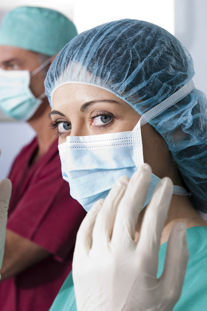 Portrait of a female surgeon, operation in the background - Φωτογραφία, εικόνα