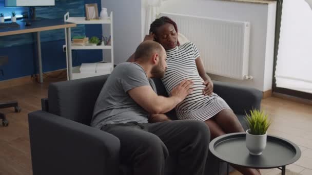 Married interracial couple bonding over child sitting at home - Footage, Video