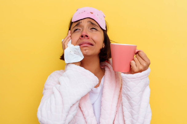 Junge Mischlingshündin mit Erkältung trinkt Tee auf gelbem Hintergrund - Foto, Bild
