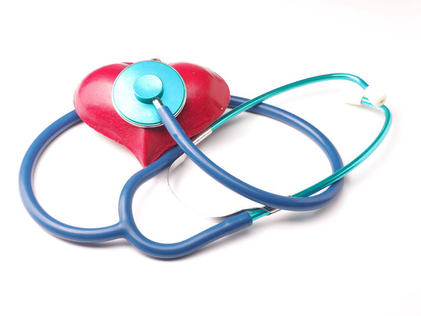 Stethoscope with a red heart shape on a white table, health care - Foto, afbeelding