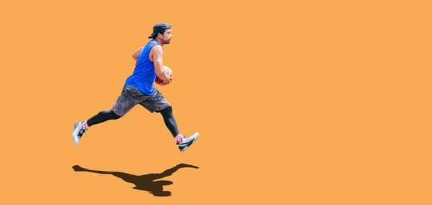 Asijský basketbalista cvičení dribling na barevném pozadí s výstřižkem paht - Fotografie, Obrázek