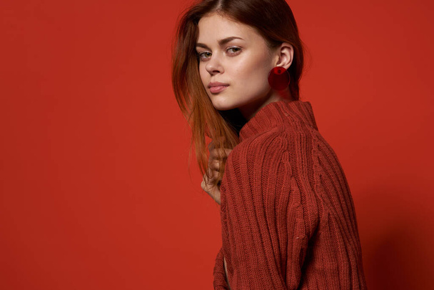 レッドセーターイヤリングの明るい女性の魅力化粧品モデル - 写真・画像