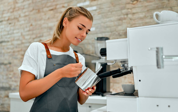 Fiatal vonzó nő barista készít kávét egy kávézóban. - Fotó, kép