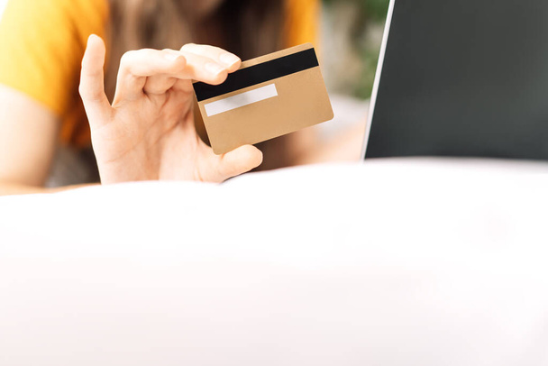 Girl holding gold-colored credit card. - Photo, image