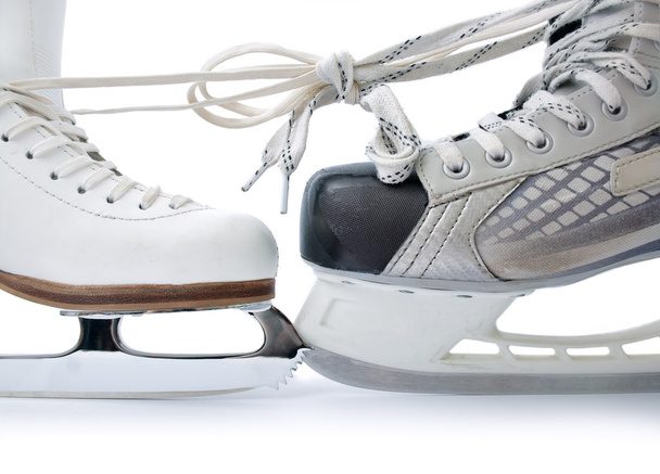 Коньки для фигурного катания и хоккейного конька связаны друг с другом крупным планом на белом фоне
 - Фото, изображение