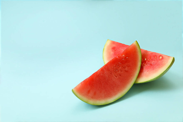 Ripe watermelon slices on blue background, space for text - Zdjęcie, obraz