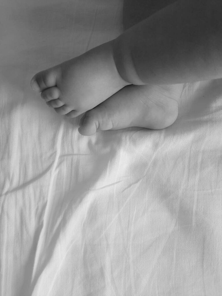 Pies de un recién nacido en la cama - Foto, Imagen