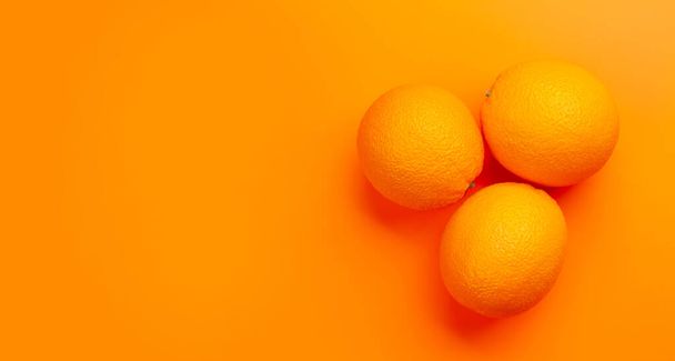 Fruta naranja madura fresca sobre fondo naranja. Vista superior plano con espacio de copia - Foto, imagen