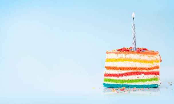 Torta di compleanno con candela accesa su sfondo blu con spazio copia per i tuoi saluti - Foto, immagini