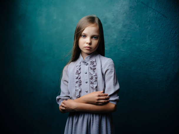 χαριτωμένο κοριτσάκι με φόρεμα που ποζάρει λυπημένο βλέμμα - Φωτογραφία, εικόνα