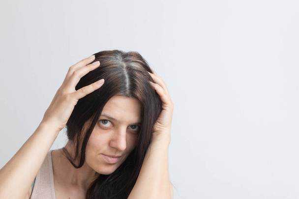 Fragmente grauer Haare auf dem Kopf einer jungen Frau. Frühe graue Haare. Graue Haarfarbe und -struktur. Kopierraum - Foto, Bild
