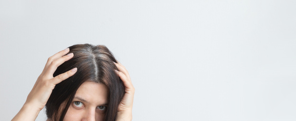 Genç bir kadının kafasında gri saç telleri var. Eski gri saç konsepti. Gri saç rengi ve yapısı. Uzayı kopyala Sancak biçimi - Fotoğraf, Görsel