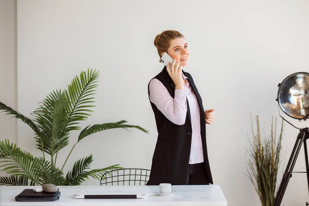 Business woman is talking on the phone in the white modern office.  - Foto, Bild