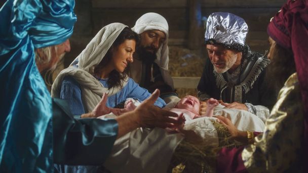 Magi and parents speaking over manger with baby Jesus - Photo, Image