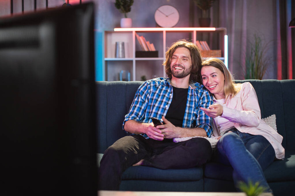 Caucasian couple smiling sincerely while watching TV - Valokuva, kuva