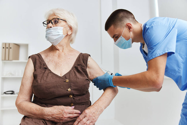 mujer anciana en pasaporte de vacuna hospitalaria en máscaras médicas - Foto, imagen