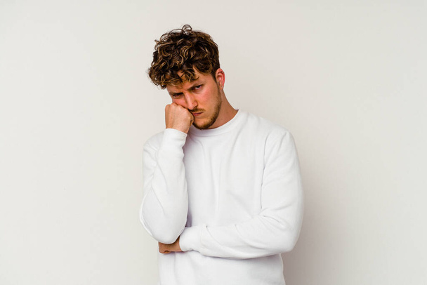 Young caucasian man isolated on white background tired of a repetitive task. - 写真・画像
