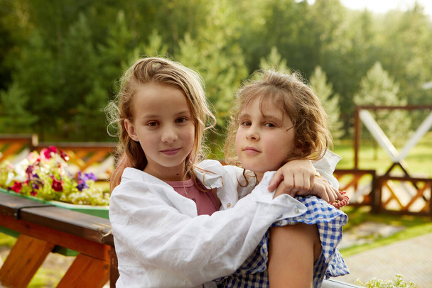 Meisjes knuffelen op terras in de zomer Meisjes dag - Foto, afbeelding