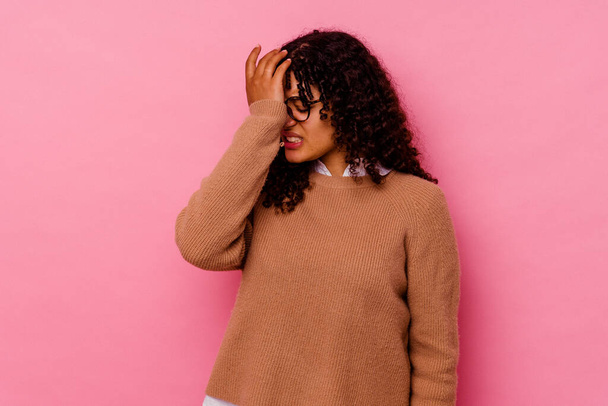 Young mixed race woman isolated on pink background forgetting something, slapping forehead with palm and closing eyes. - Foto, Imagem