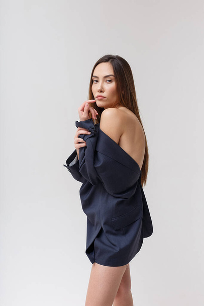 young attractive asian woman in blue suit isolated on grey studio background - Foto, afbeelding