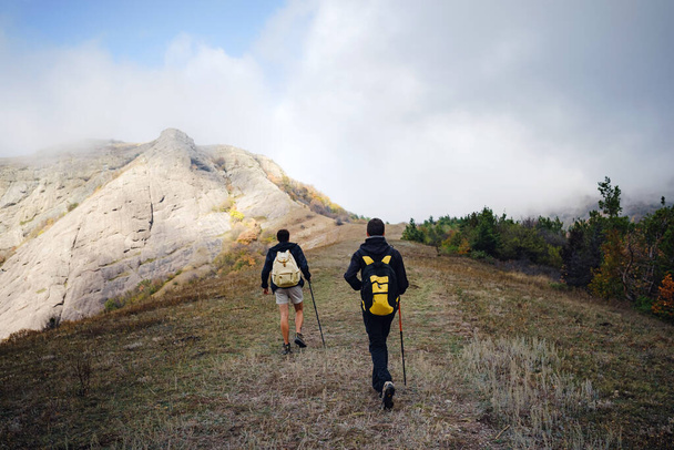 Két férfi barát hátizsákkal túrázás együtt ősszel természet. - Fotó, kép