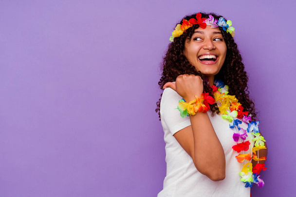 Young Hawaiian woman isolated on purple background points with thumb finger away, laughing and carefree. - Fotó, kép