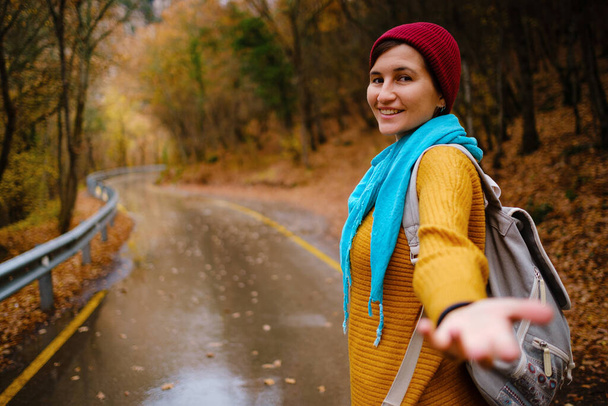 Sırt çantasıyla dağlarda yürüyen genç bir kadın. - Fotoğraf, Görsel