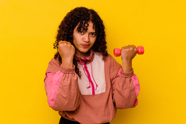 Young mixed race sport woman isolated on yellow background - Photo, Image