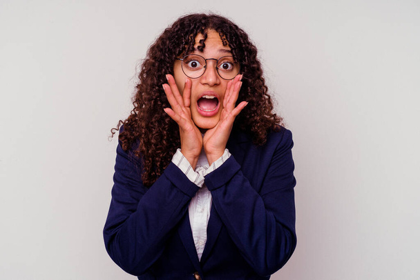 Young business mixed race woman isolated on white background shouting excited to front. - 写真・画像