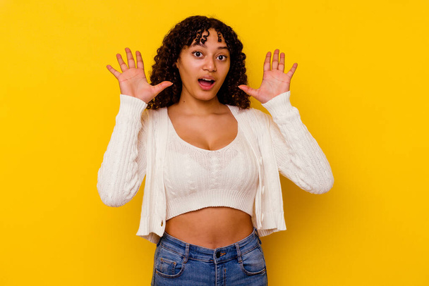Young mixed race woman isolated on yellow background screaming to the sky, looking up, frustrated. - Foto, Imagen